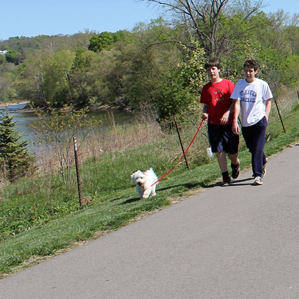 two boys walking a dog on the Riverside Park hike/bike trail