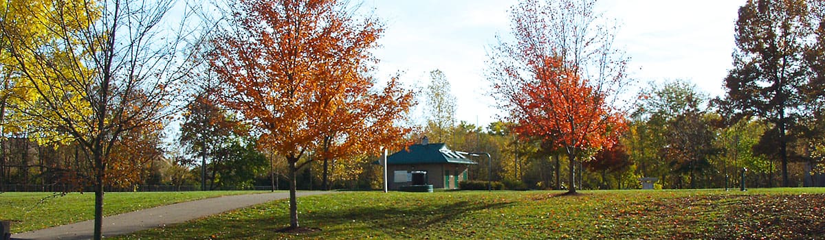 Kellogg Park in the fall with vibrant colored trees and image of restroom building in the background