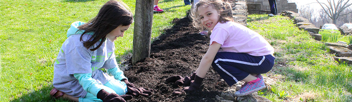 two girl volunteers help to mulch at Johnson Hills Park during Great American Cleanup